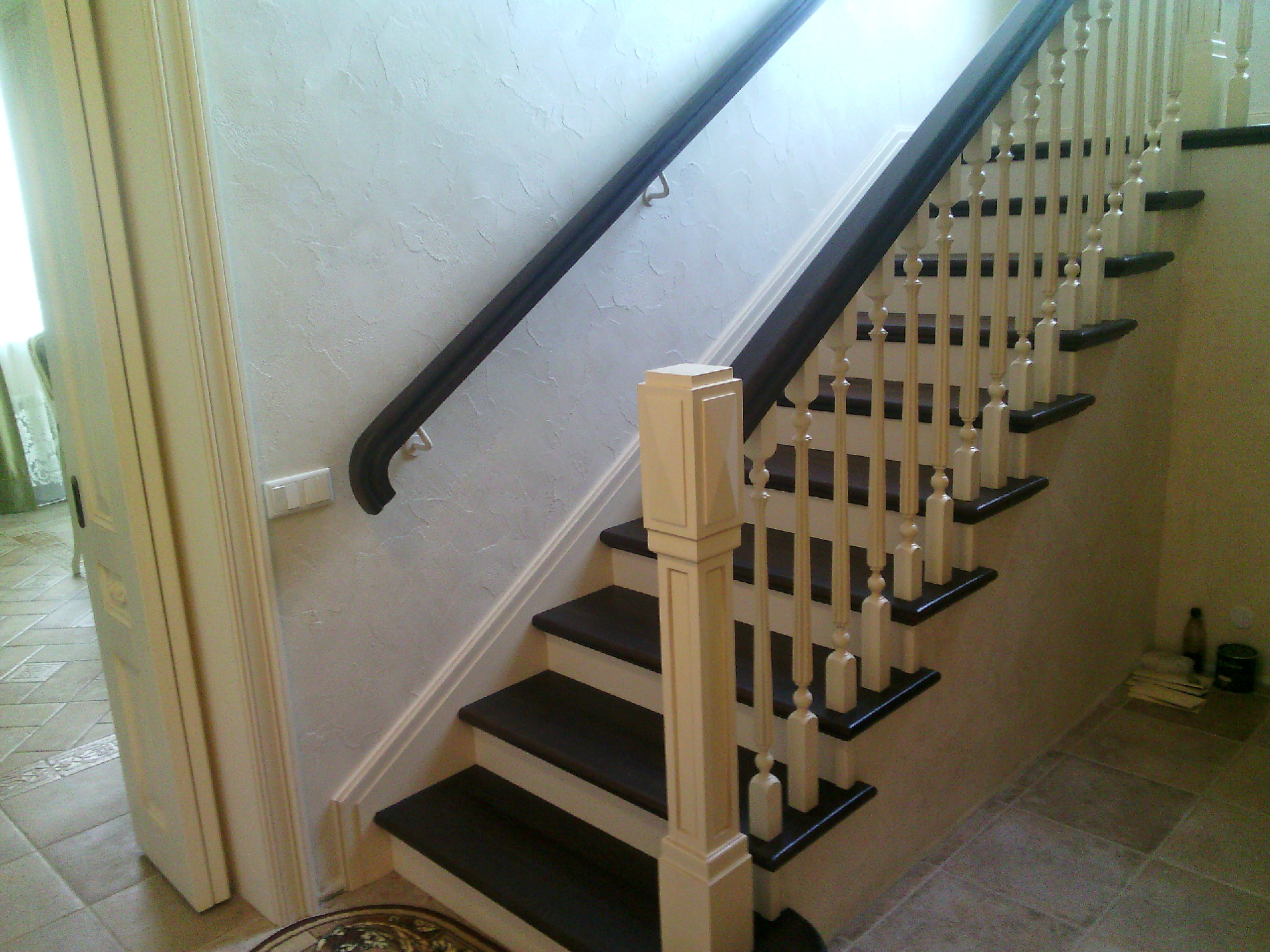 Белая классическая лестница с тёмными деревянными ступенями и перилами