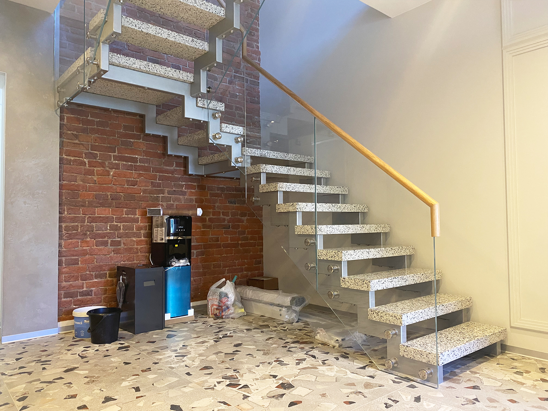 Строгая современная каменная лестница с металлическим основанием и стеклянным ограждением