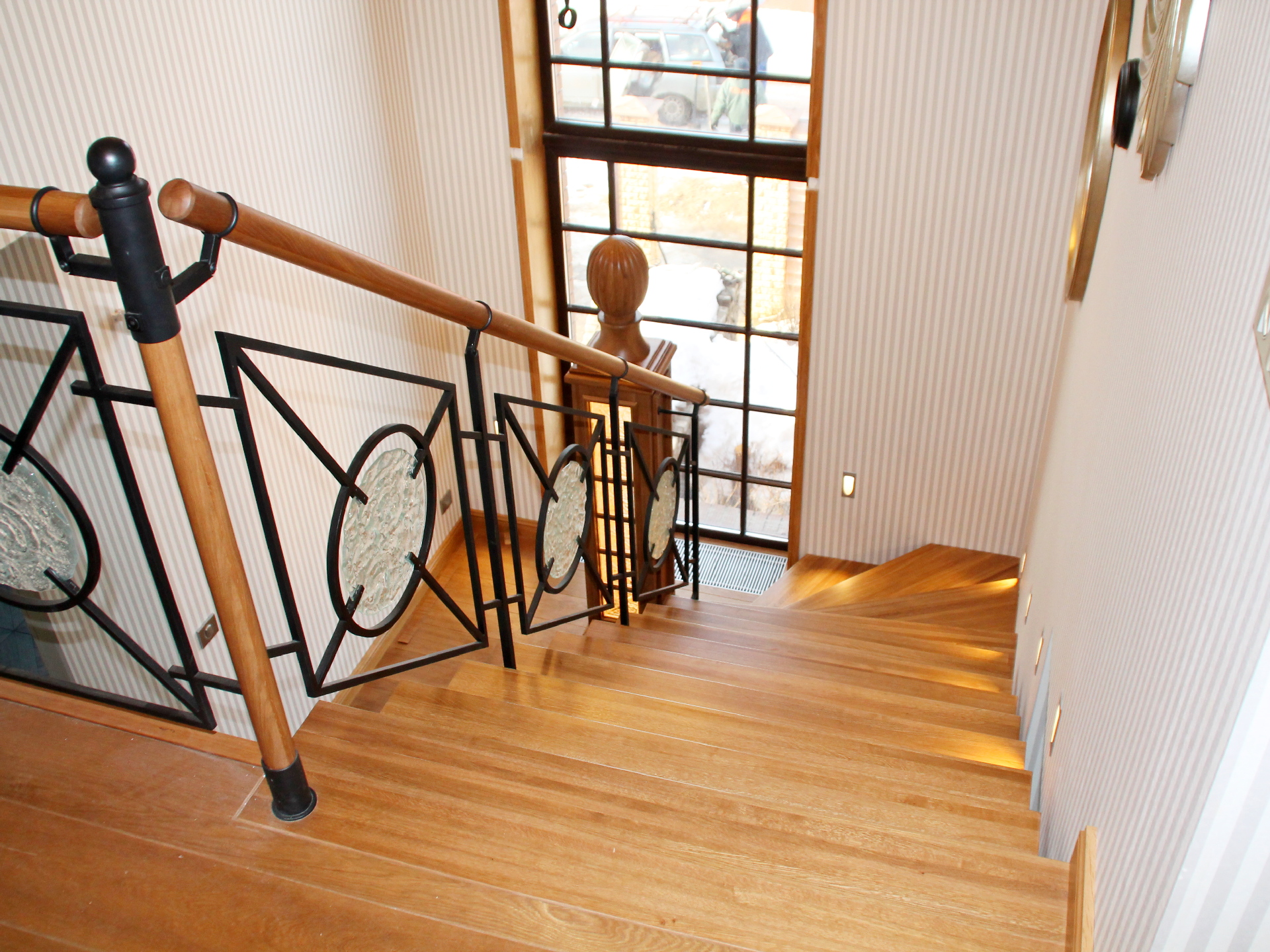 Деревянная лестница с кованным ограждением из металла и стекла