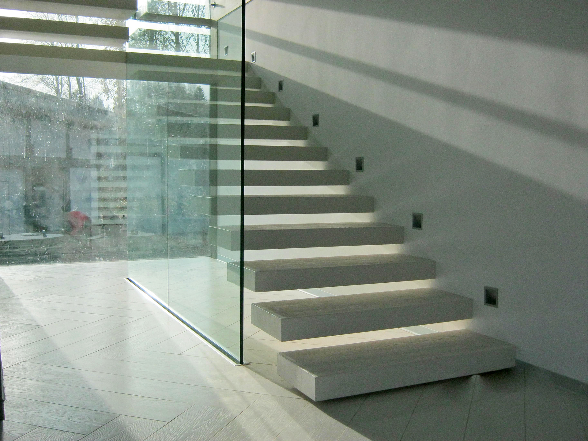Светлая консольная лестница со стеклянным ограждением